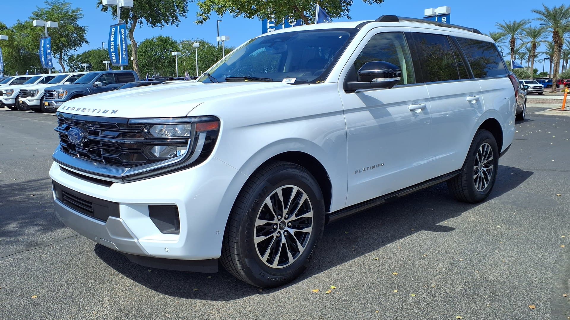 White 2025 Ford Expedition Platinum full-size SUV parked on a dealership lot, seen from the front left