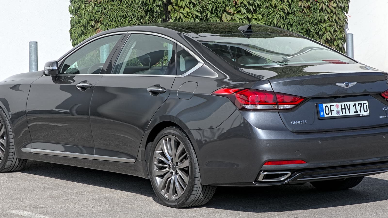 Silver Genesis G80 DH-generation luxury sedan at an auto show, front left three-quarter view