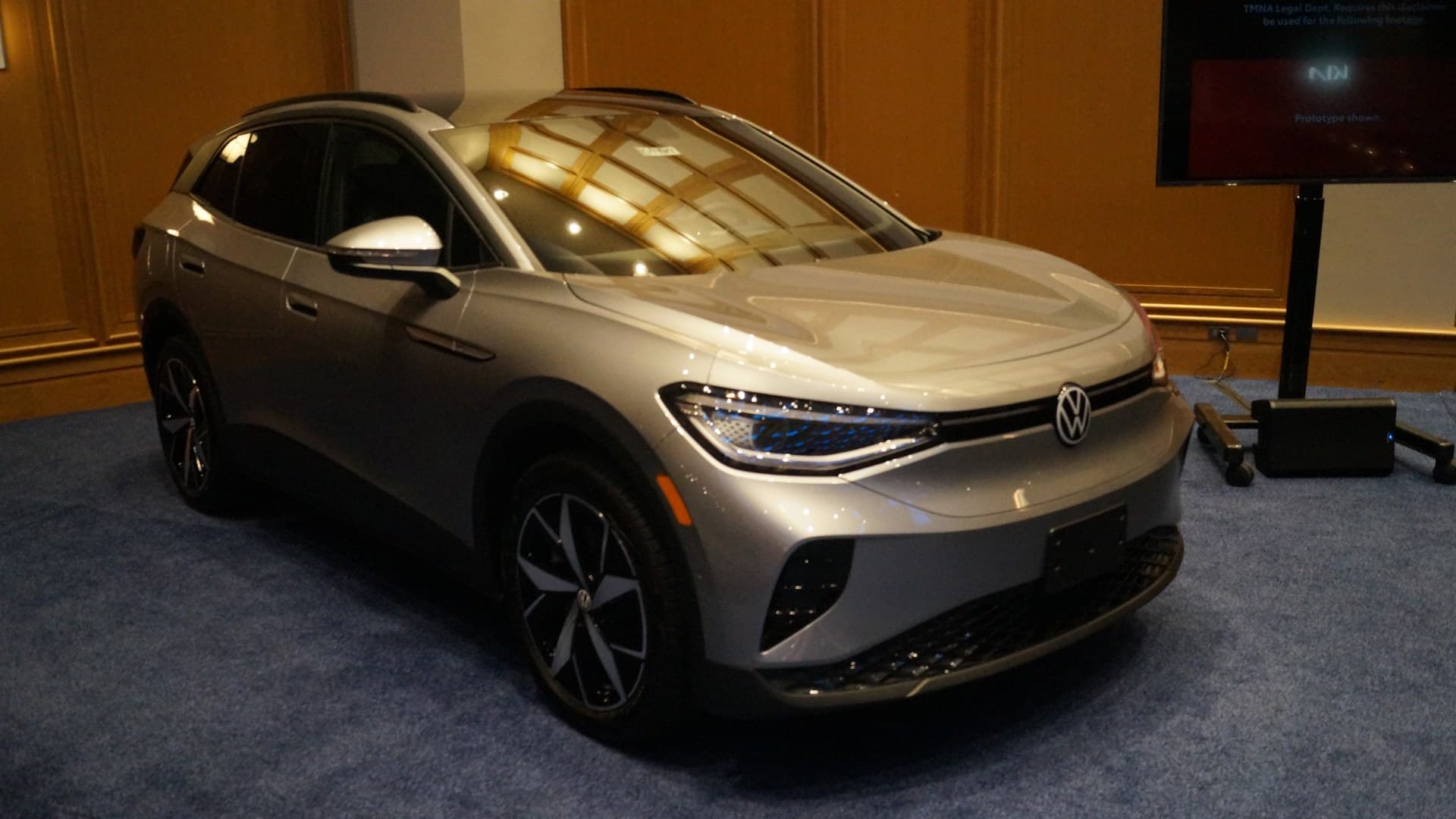 Silver Volkswagen ID.4 electric SUV on display indoors, seen from the front right